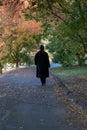 young man with black jacket walking in the fall
