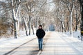 Young man in black jacket walks alone on snowy road. Travel alone concept. Lifestyle. Royalty Free Stock Photo