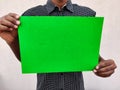 Young man in black shirt holding a blank green color chart Royalty Free Stock Photo