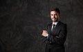 Young man in a black suit on a gray background. Bearded businessman smiling Royalty Free Stock Photo