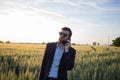 Portrait of stylish male with cellphone summer wheat field Royalty Free Stock Photo