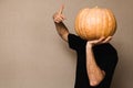 Young man in black t-shirt holding big pumpkin in front of his face Royalty Free Stock Photo