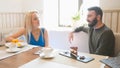 Young man and blonde woman takes the cups of coffee at the cafe Royalty Free Stock Photo