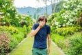 Young man blowing nose in front of blooming tree. Spring allergy concept Royalty Free Stock Photo