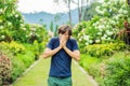 Young man blowing nose in front of blooming tree. Spring allergy concept Royalty Free Stock Photo