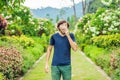 Young man blowing nose in front of blooming tree. Spring allergy concept Royalty Free Stock Photo