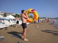 The young man blows his ring on the beach