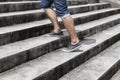 Young man in blue jeans and sneaker shoes walking up stairs outdoors background with copy space for text. Concept of person`s Royalty Free Stock Photo