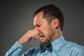 Young man - disgusted expression closing his nostrils with finge Royalty Free Stock Photo