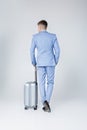 Young man in blue suit with suitcase