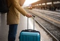 A young man with a blue suitcase is waiting for the train. Train station Royalty Free Stock Photo