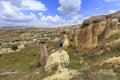 A young man stands on a rock and looks at the opening landscape and blue sky in Cappadocia Royalty Free Stock Photo