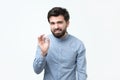 Young man in blue t-shirt showing OK sign in secret. Royalty Free Stock Photo