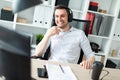 A young man in headphones sits at a computer desk. Royalty Free Stock Photo