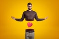 Young man with body cut in two at waist, upper body in air, with cute red valentine heart levitating between upper and Royalty Free Stock Photo