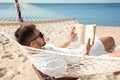 Young man  book in hammock on beach Royalty Free Stock Photo