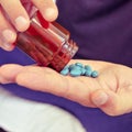 Young man with a bottle of blue pills Royalty Free Stock Photo