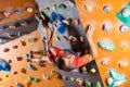 Young man bouldering in indoor climbing gym