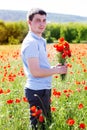 Young man with bouquet of poppies Royalty Free Stock Photo