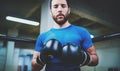 Young man in boxing gloves. Young Boxer fighter over blurred background.Boxing man ready to fight. Boxing, workout Royalty Free Stock Photo