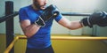 Young man boxing workout on ring in a fitness club. Caucasian male boxer in black gloves. Muscular strong man on