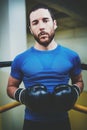 Young man boxing workout on ring in a fitness club. Caucasian male boxer in black gloves. Muscular strong man on