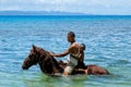 Young man with a boy riding horse on the beach on Taveuni Island Royalty Free Stock Photo