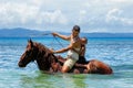 Young man with a boy riding horse on the beach on Taveuni Island Royalty Free Stock Photo