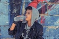 Young man boy skater drinking water over graffiti art urban wall background Royalty Free Stock Photo