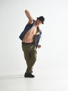 Young man breakdancer in hat dancing hip-hop in studio  on white background. Break dance lessons Royalty Free Stock Photo