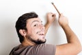 Young man bricolage hammering nail wall