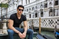 Young Man on Bridge Over Narrow Canal in Venice Royalty Free Stock Photo