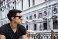 Young Man on Bridge Over Narrow Canal in Venice Royalty Free Stock Photo