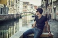 Young Man on Bridge Over Narrow Canal in Venice Royalty Free Stock Photo