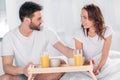 young man brought breakfast in bed for smiling girlfriend Royalty Free Stock Photo