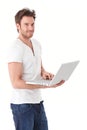 Young man browsing internet on laptop smiling Royalty Free Stock Photo