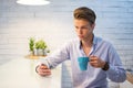 Young man browsing internet on smartphone and drinking coffee at home. Royalty Free Stock Photo