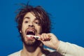 Young man brush teeth with toothpaste on blue background, copy space. Cleaning teeth and in the bathroom. Handsome man Royalty Free Stock Photo