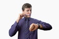 Young man brushing his teeth also looks on at watch on white background Royalty Free Stock Photo