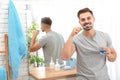 Young man brushing teeth in bathroom at home Royalty Free Stock Photo