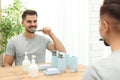 Young man brushing teeth near mirror in bathroom Royalty Free Stock Photo