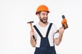 Young man builder holding drill and hammer Royalty Free Stock Photo