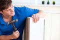 Young man building furniture using hammer and nail Royalty Free Stock Photo