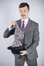 Young man in a business suit pulls out leopard bra from his hat, but he wanted tricks with wonder and wealth. emotional male feels