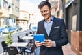 Young man business worker smiling confident using touchpad at coffee shop terrace Royalty Free Stock Photo
