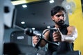 young man busy exercising for chest while listening music on wireless headphone at gym - concept of body building Royalty Free Stock Photo