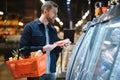 Young man buying groceries at the supermarket. Other customers in background. Consumerism concept. Royalty Free Stock Photo