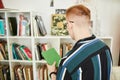 Young man buying used books in thrifting shop