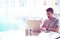 Young man, cafe and typing with laptop for communication, social media or networking at indoor restaurant. Male person Royalty Free Stock Photo