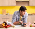 Young man calculating expences for vegetables in kitchen